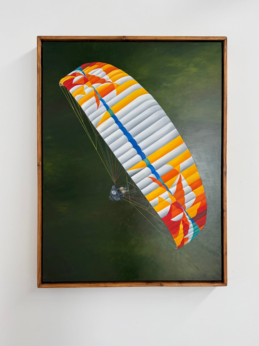 A framed art print depicting a colorful BGD Echo 2 paraglider parachute against a dark green background, mounted on a light gray wall.