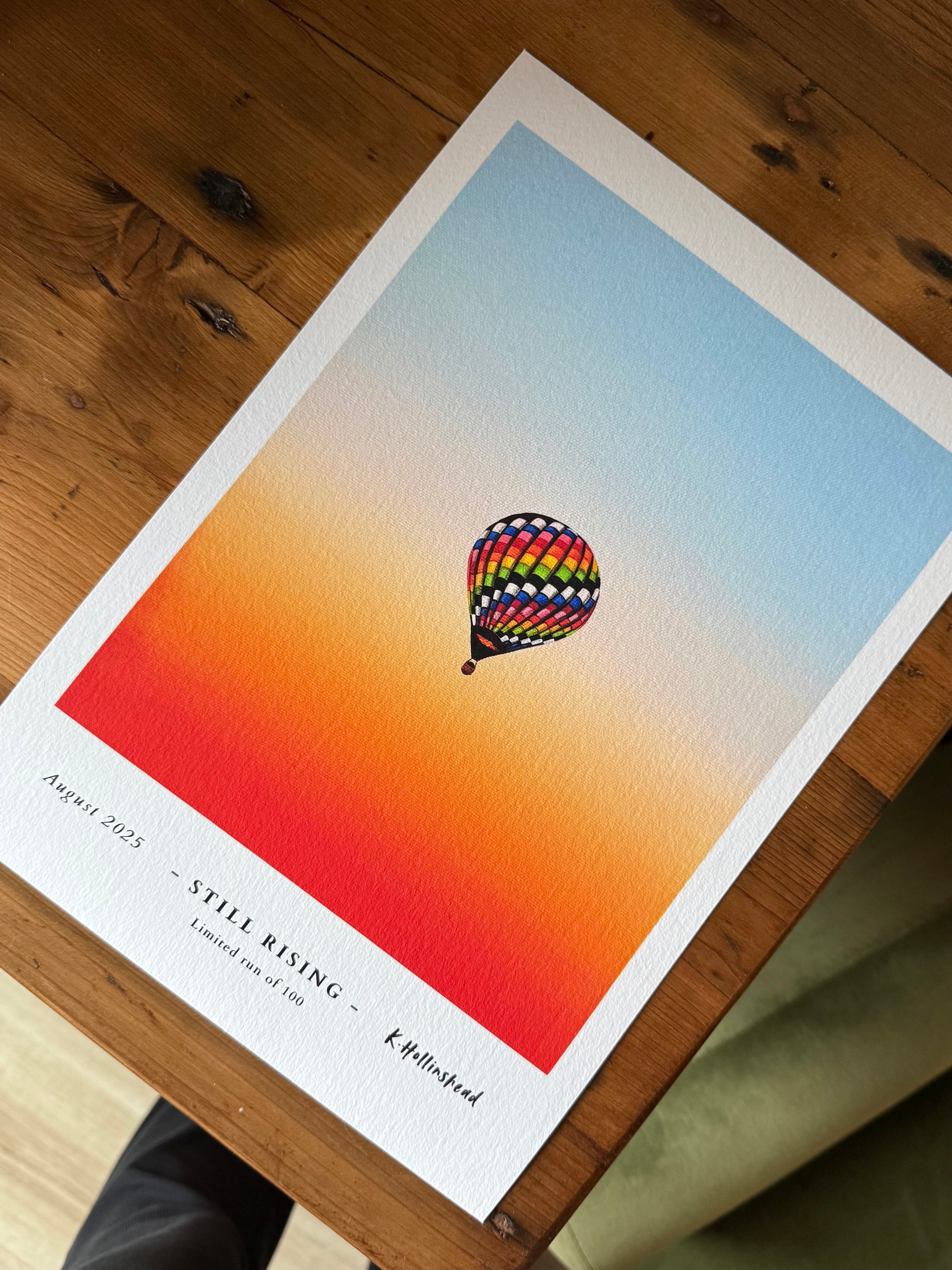 Colorful hot air balloon poster on a wooden surface