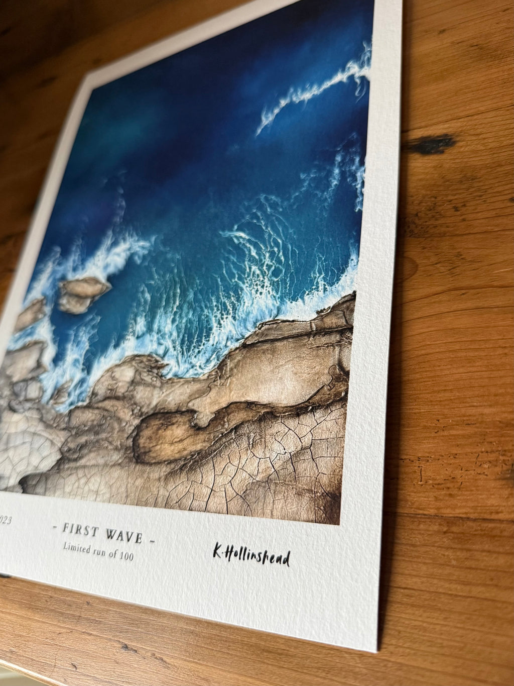 Artistic print of waves crashing against rocks on a wooden surface
