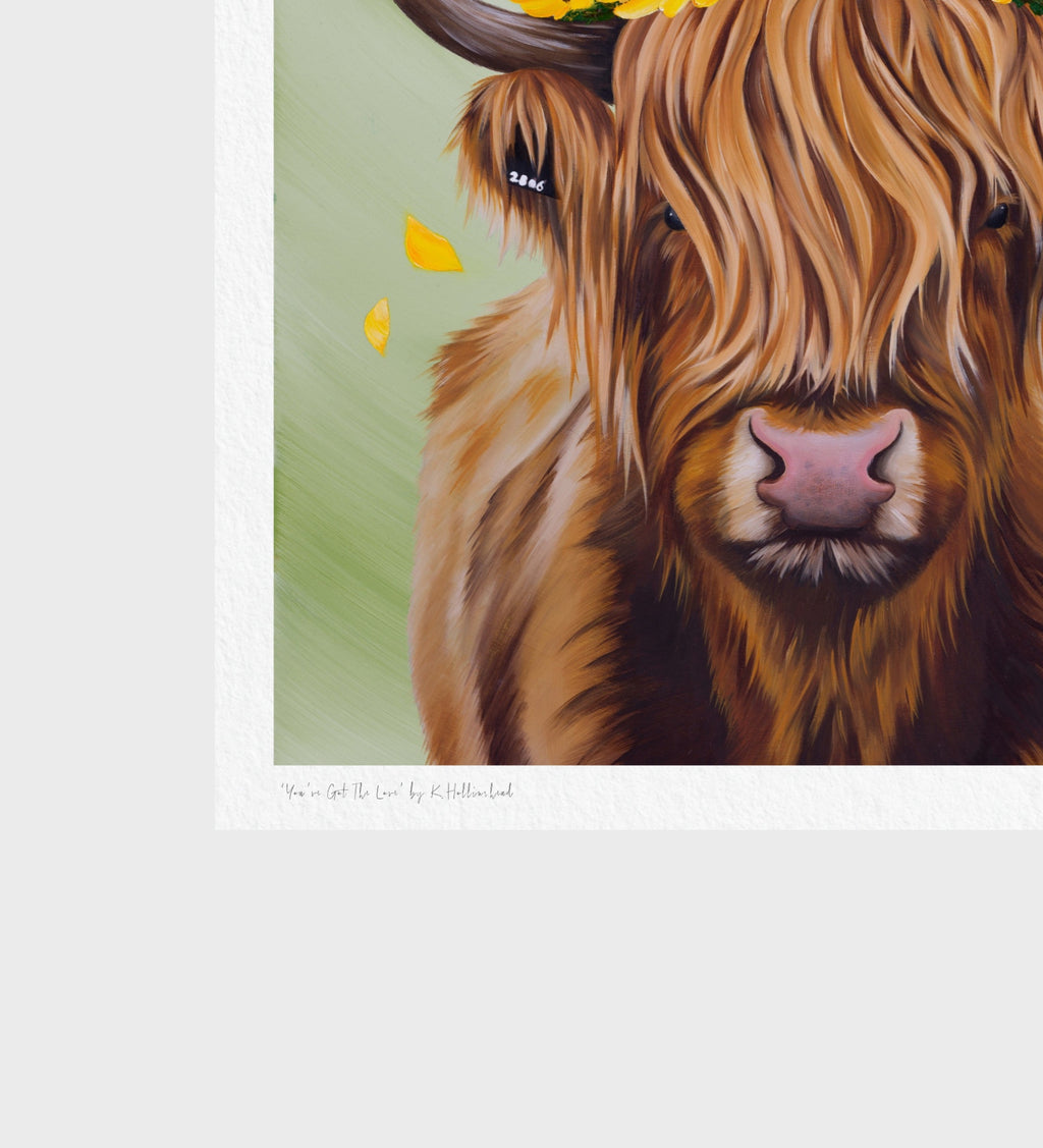 A close-up art print of a Highland cow with long shaggy brown hair, pink nose, and yellow flower accents, shown on a light gray background with a white border and small artist signature text at the bottom.